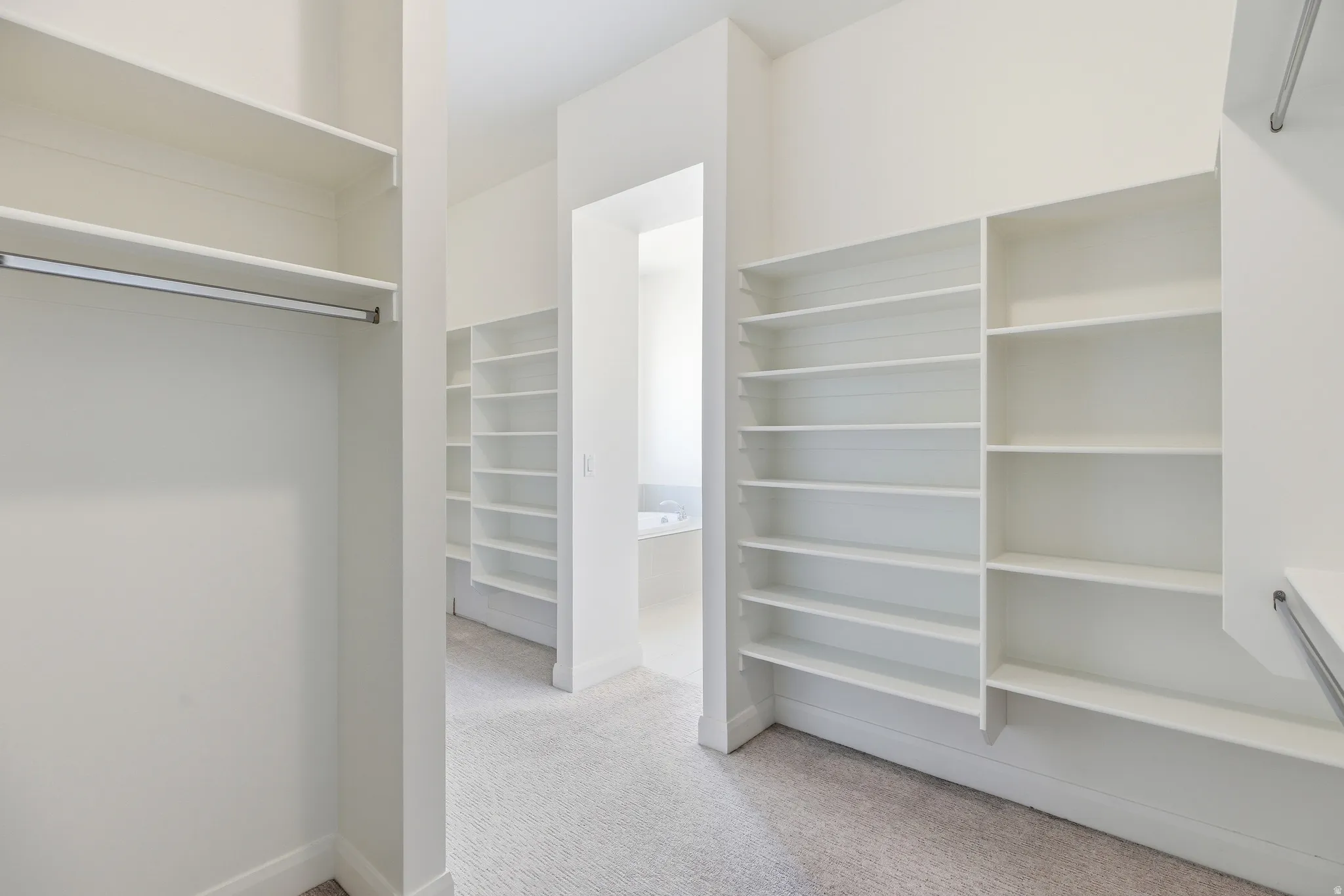 Walk in closet featuring light colored carpet