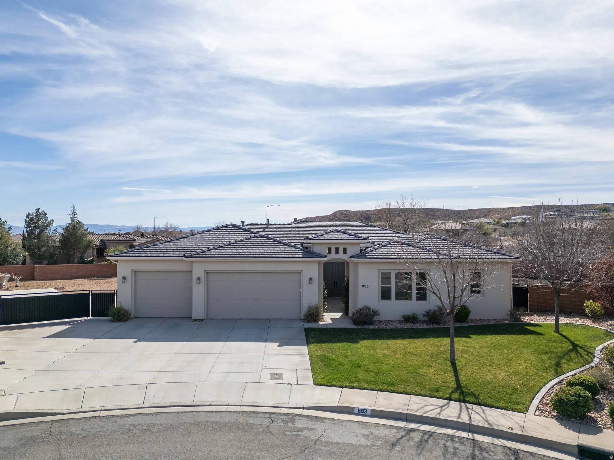 View of front of property with a garage, driveway, and stucco siding
