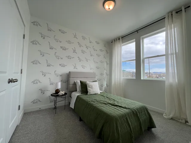 Bedroom featuring light carpet and wallpapered walls