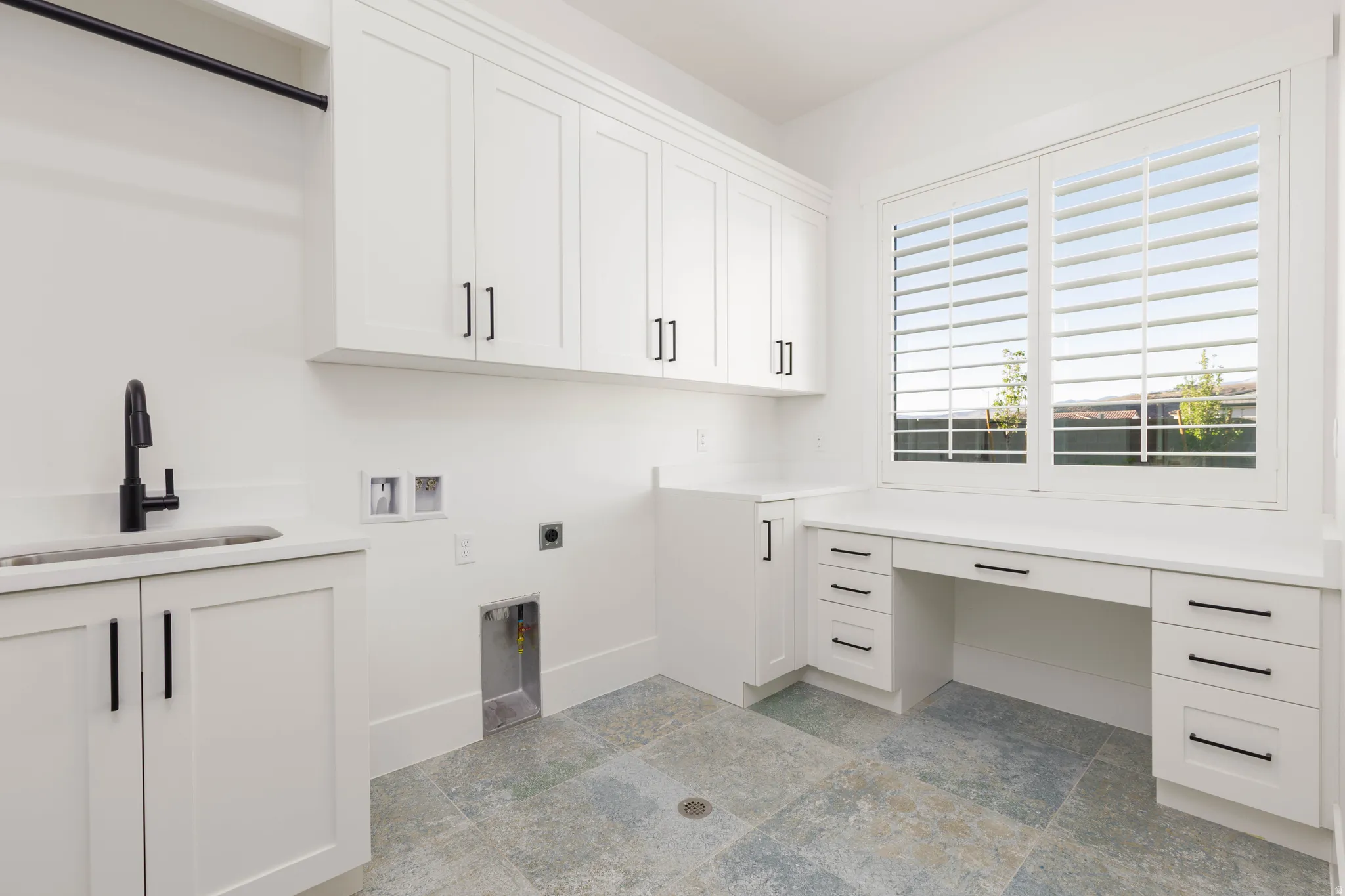 Laundry room with washer hookup, electric dryer hookup, light stone finish flooring, cabinet space, and an office area