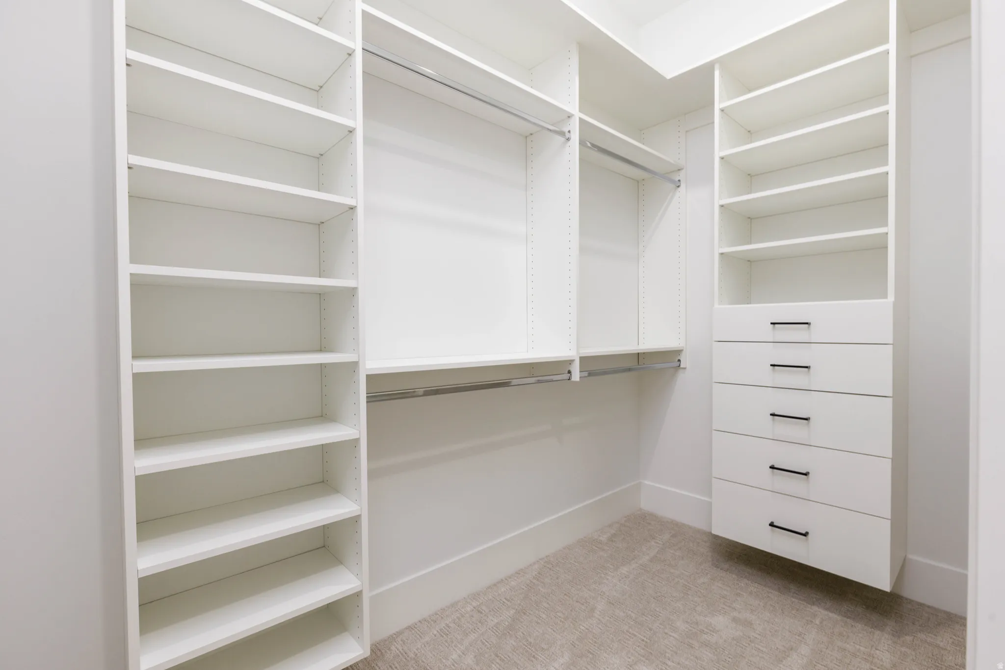 Walk in closet featuring light colored carpet