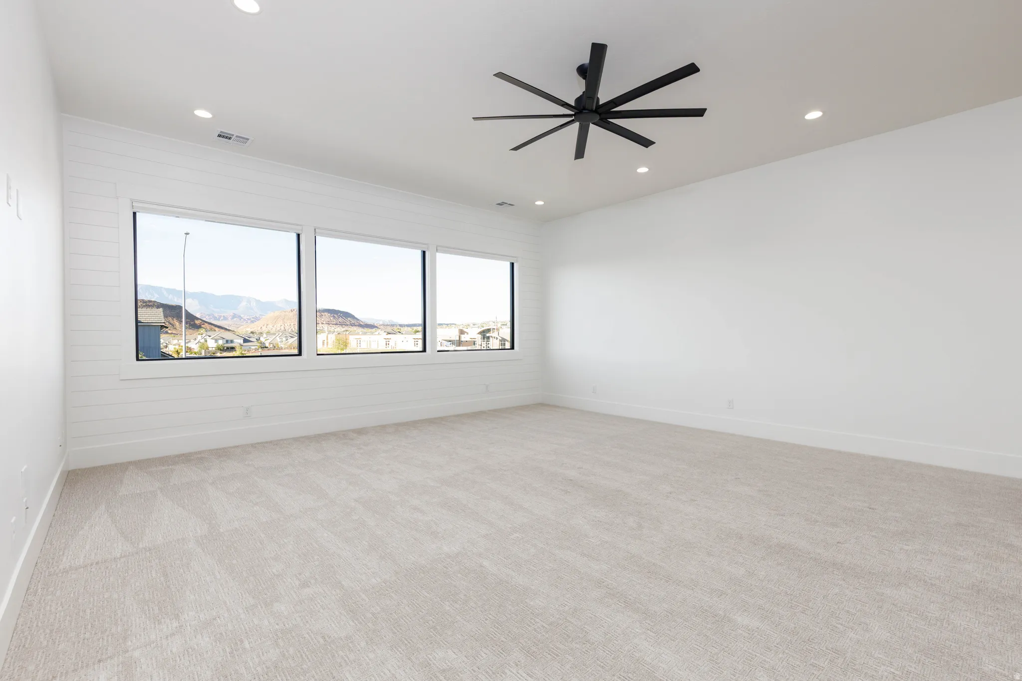 Unfurnished room featuring a mountain view, a ceiling fan, light carpet, and recessed lighting