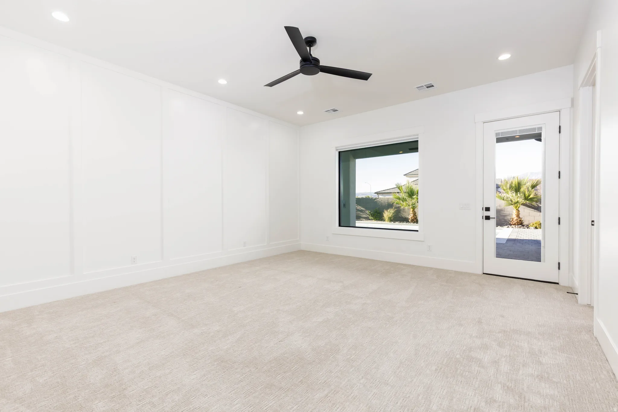 Unfurnished room featuring light colored carpet, a decorative wall, a ceiling fan, and recessed lighting
