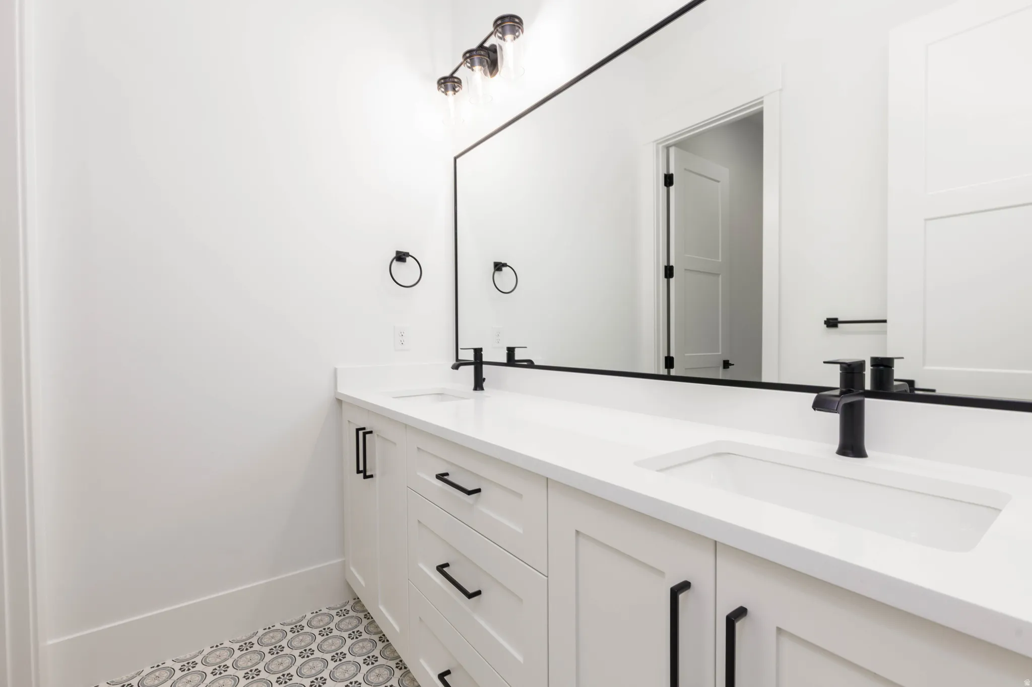 Full bathroom featuring double vanity and baseboards