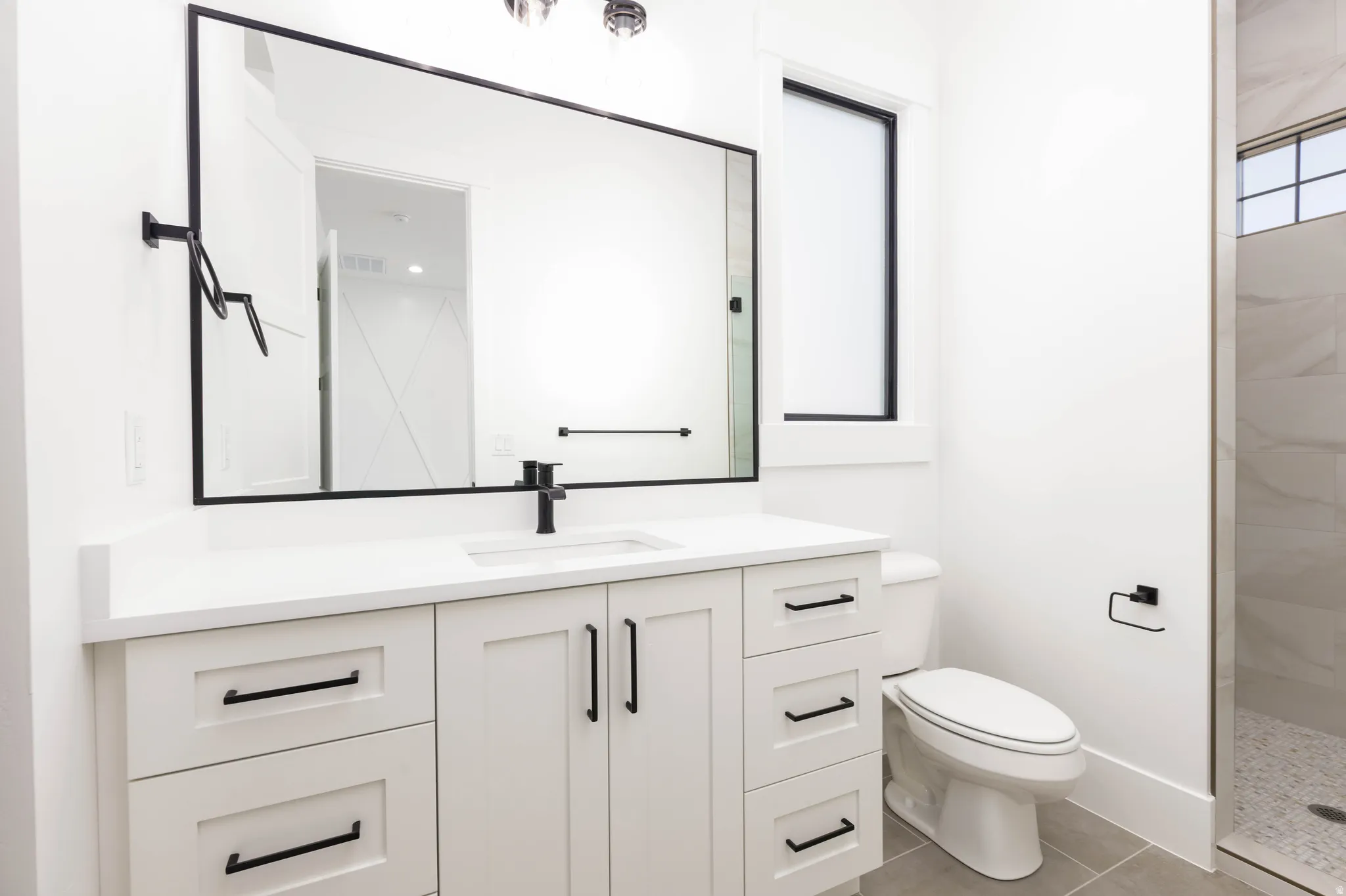 Full bath with vanity, a walk in shower, and light tile patterned floors