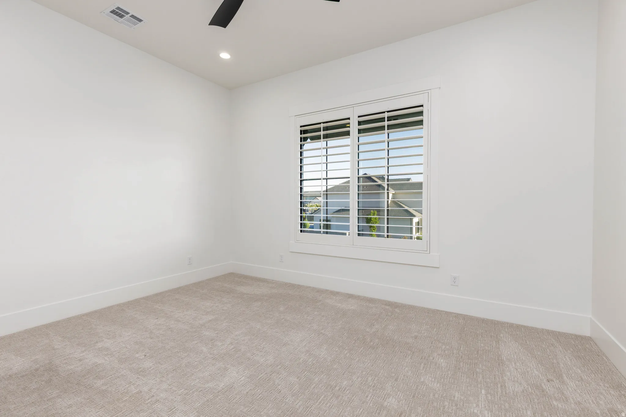 Empty room featuring light colored carpet, recessed lighting, and ceiling fan