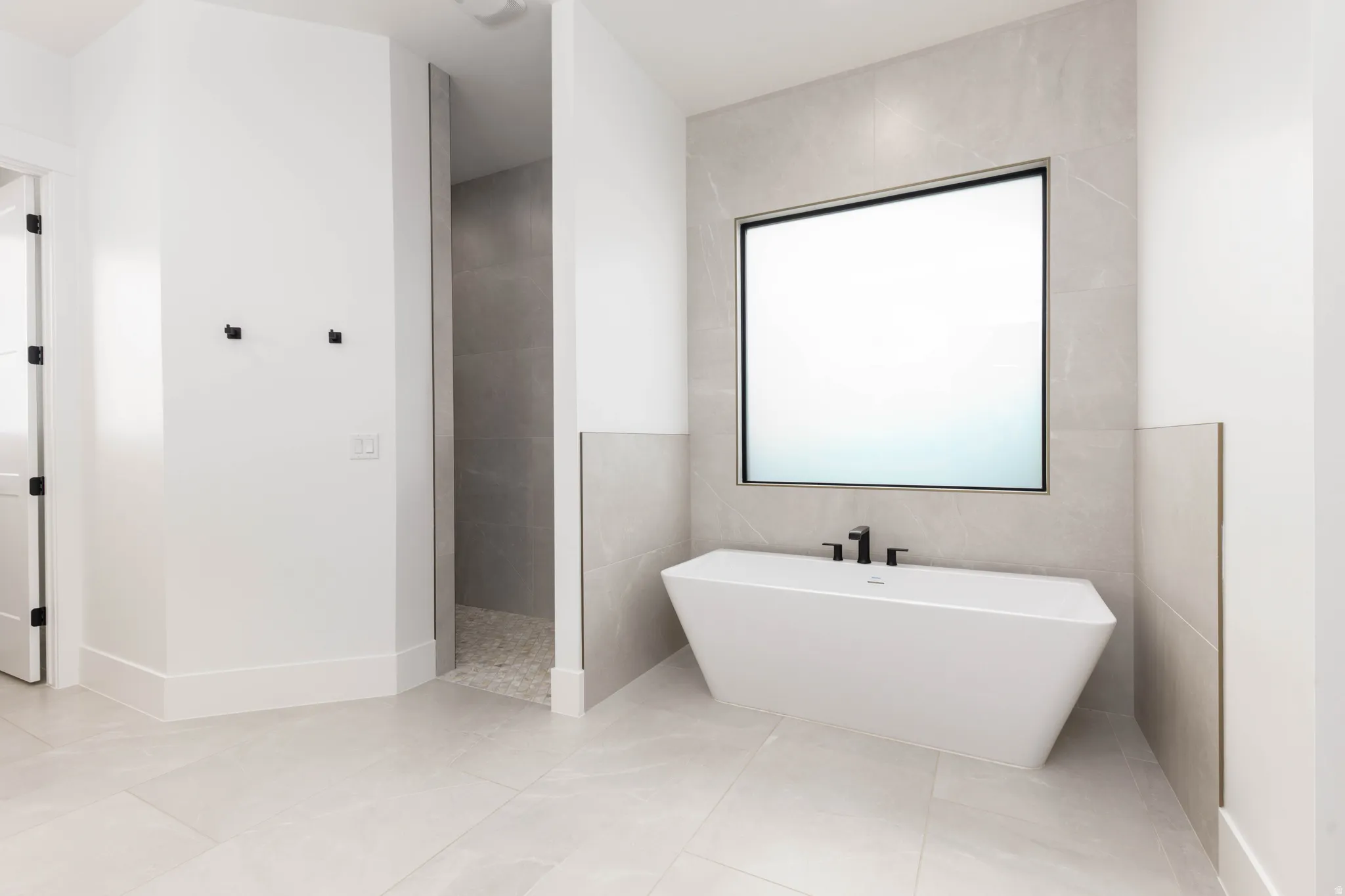 Full bath with a soaking tub, tile walls, walk in shower, and light tile patterned floors