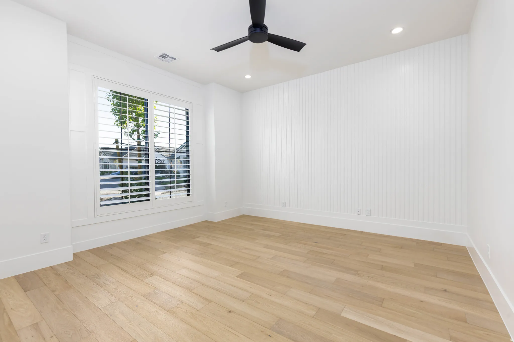 Spare room featuring light wood-style floors, ceiling fan, and recessed lighting