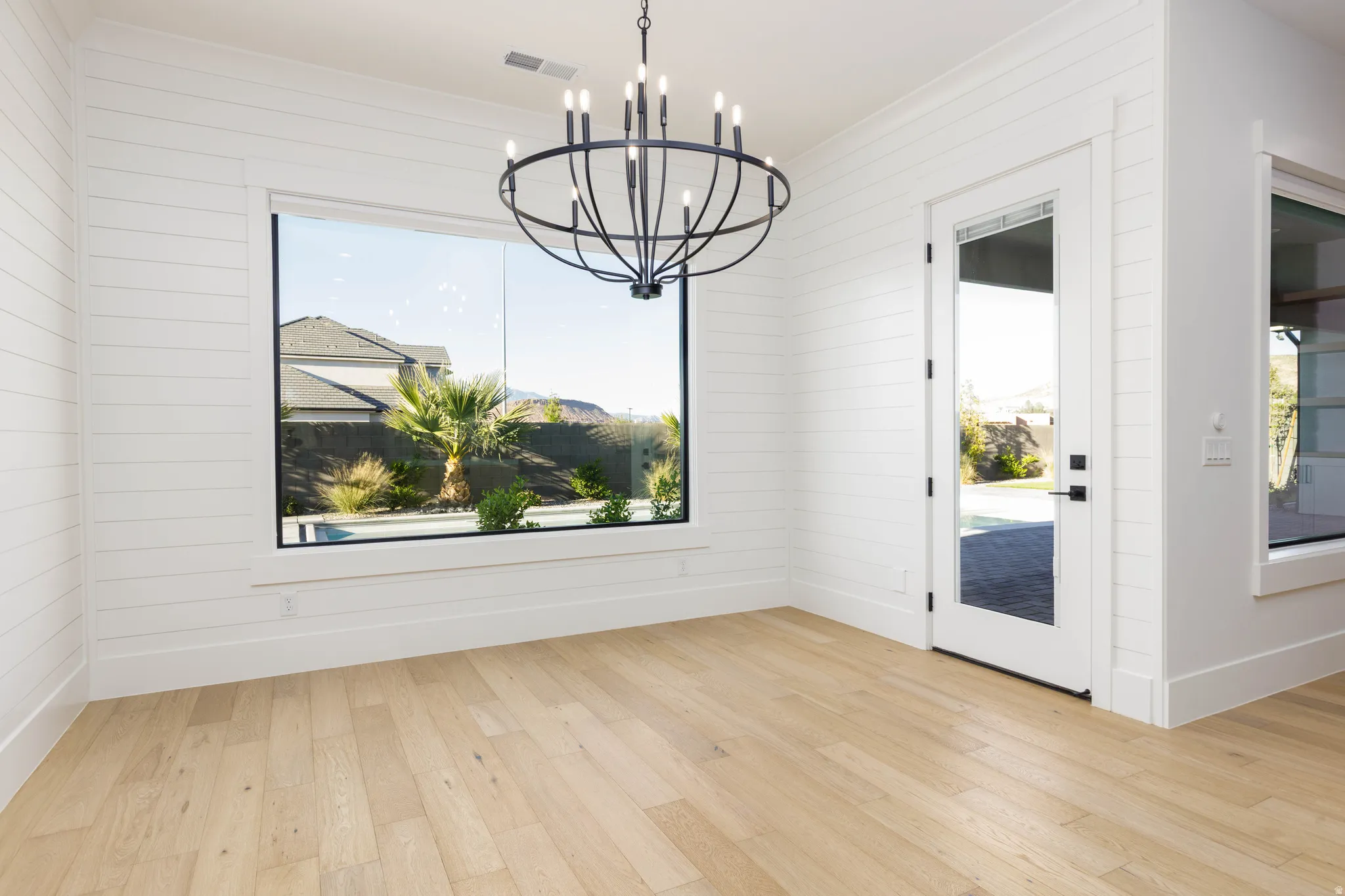 Unfurnished dining area featuring suspended lighting and light wood finished floors