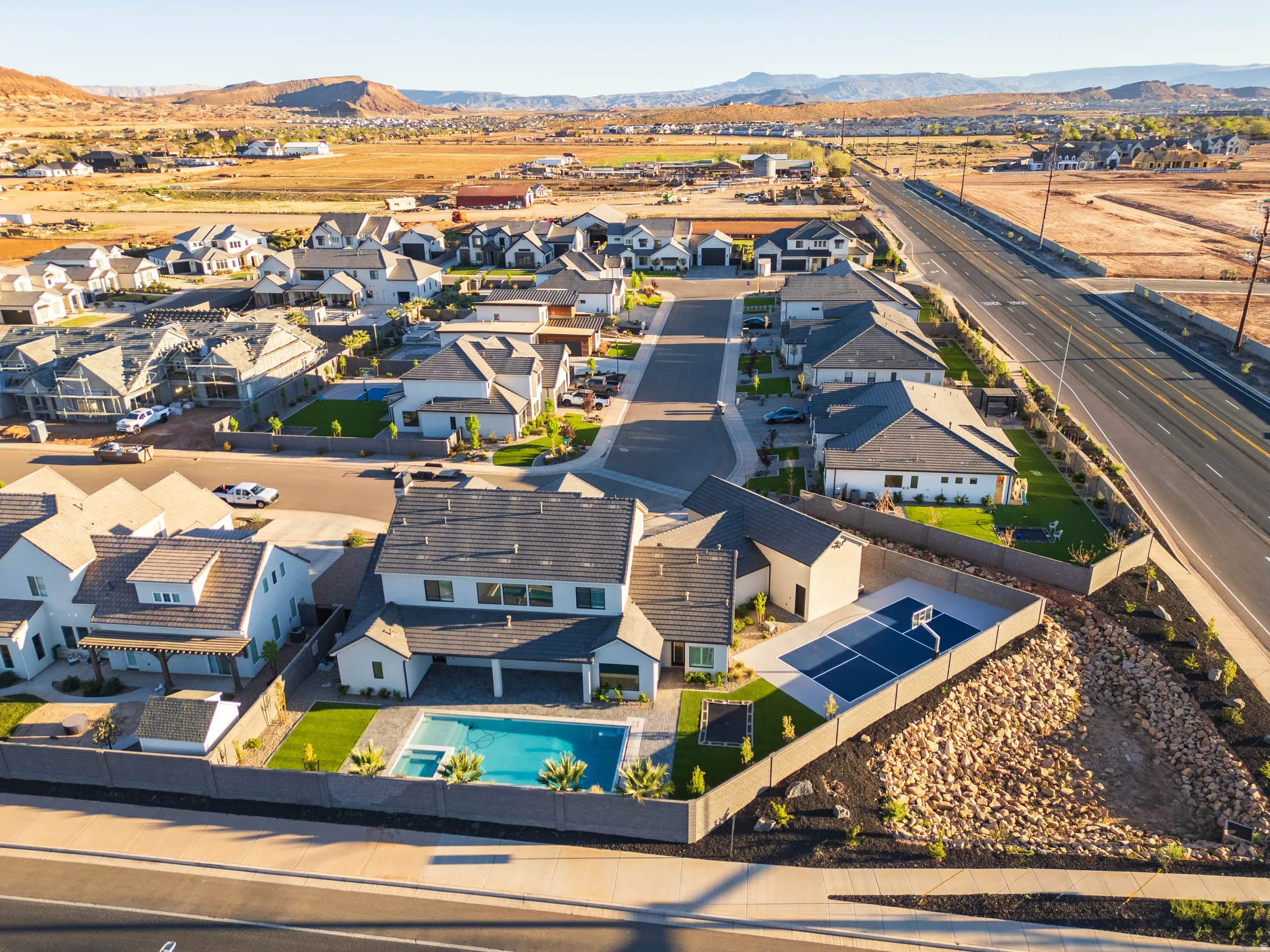 Aerial perspective of suburban area featuring a mountainous background and a pool