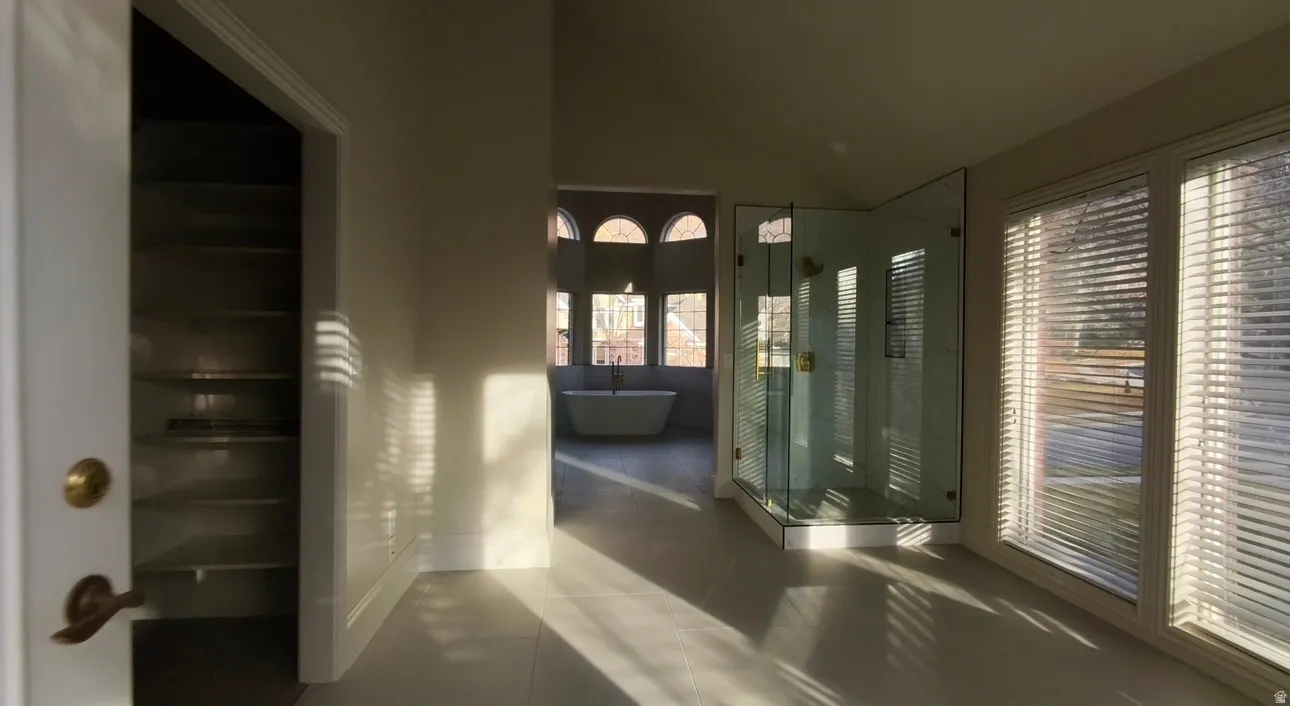 Corridor with lofted ceiling and dark tile patterned flooring
