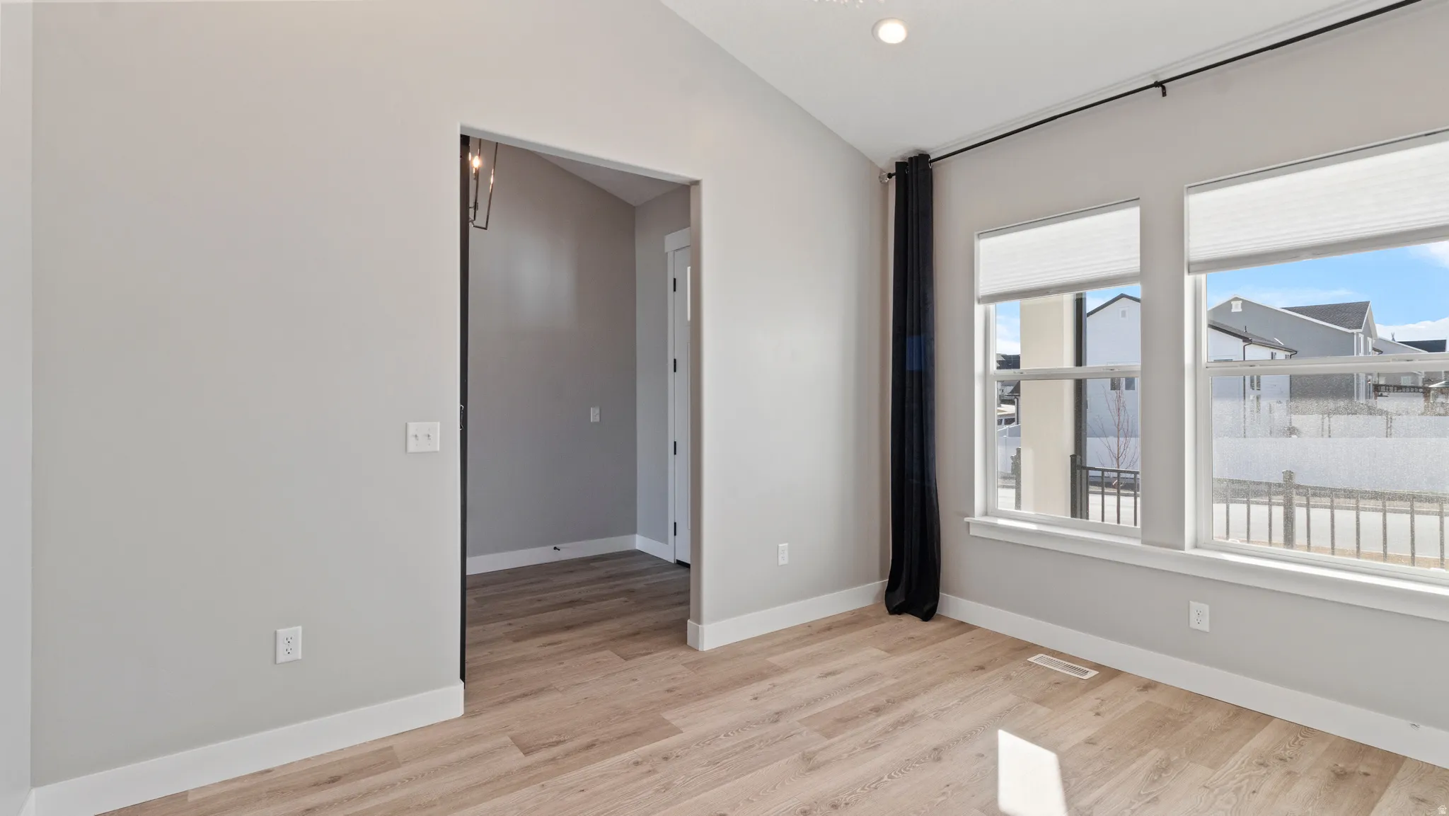 Spare room with lofted ceiling, light wood-style flooring, and recessed lighting