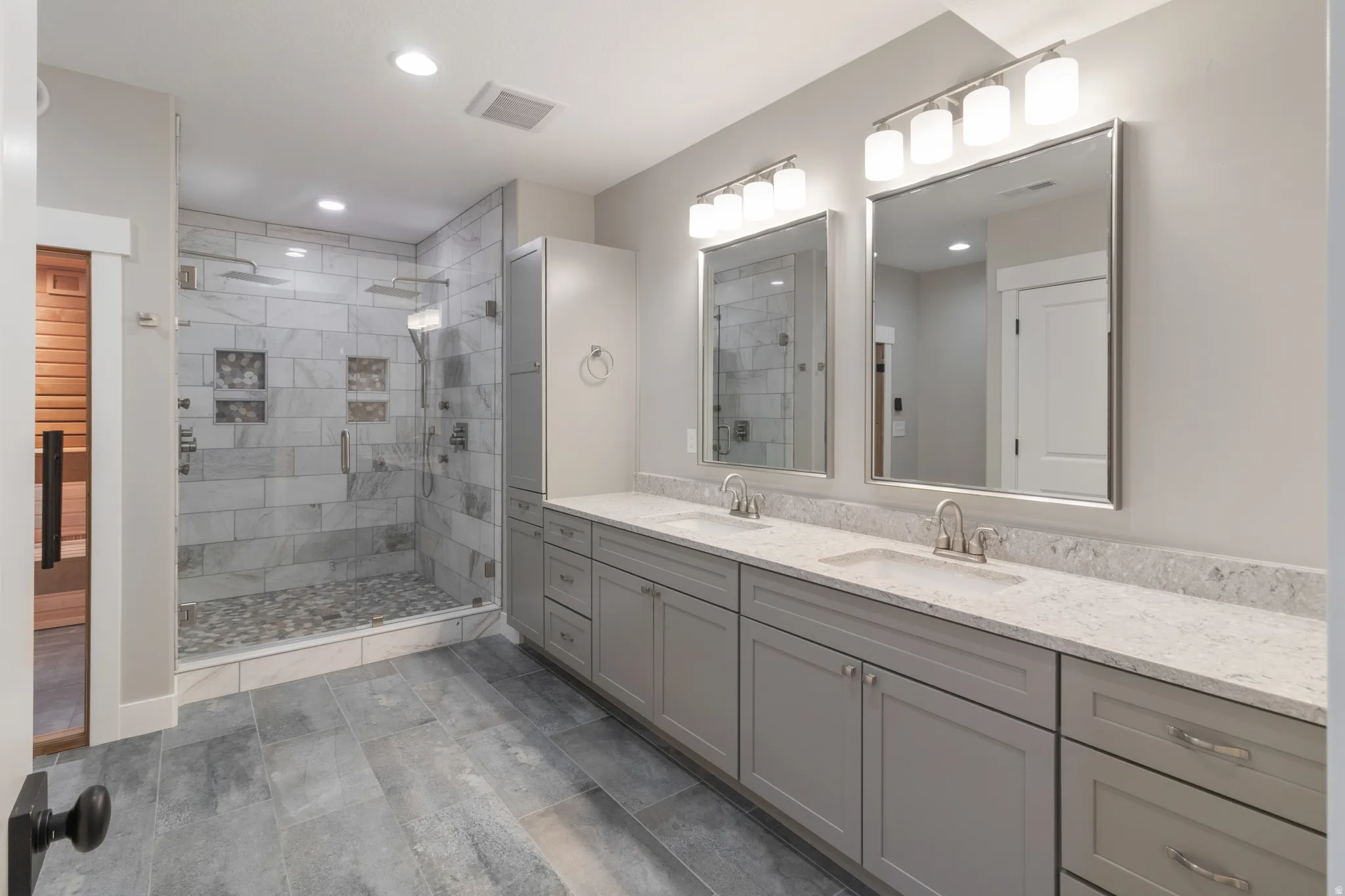 Bathroom with double vanity, a stall shower, and recessed lighting
