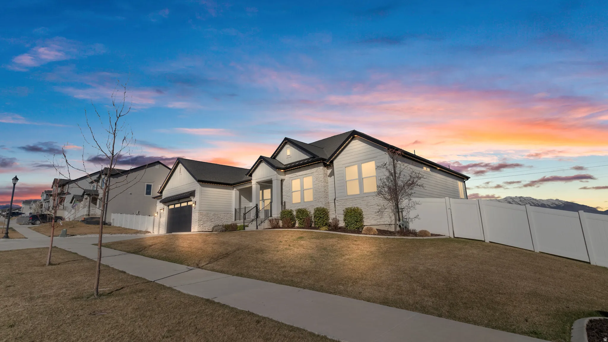 View of front of home featuring concrete driveway, an attached garage, and stone siding