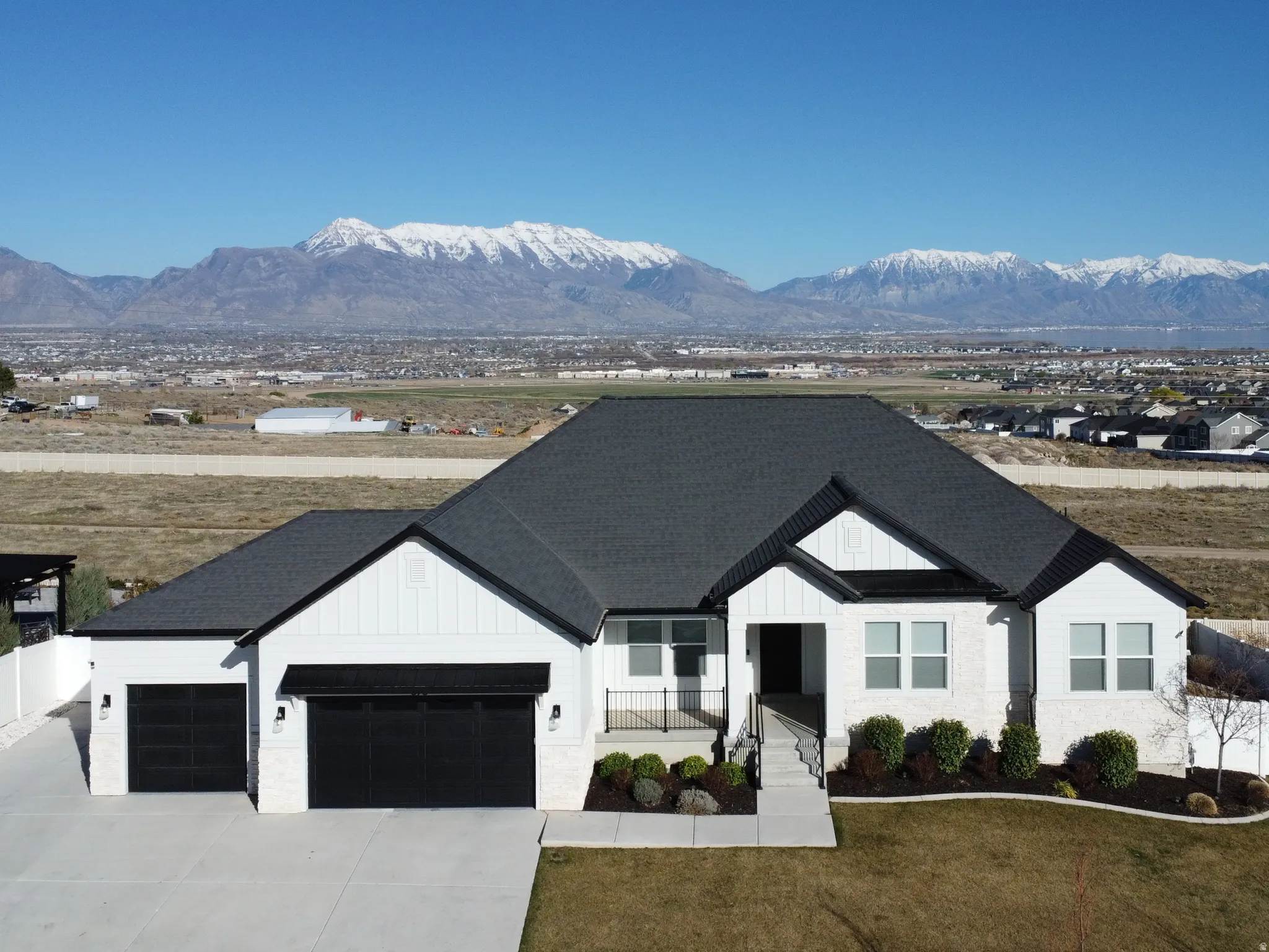 Modern farmhouse style home with board and batten siding, a mountain view, an attached garage, and a porch