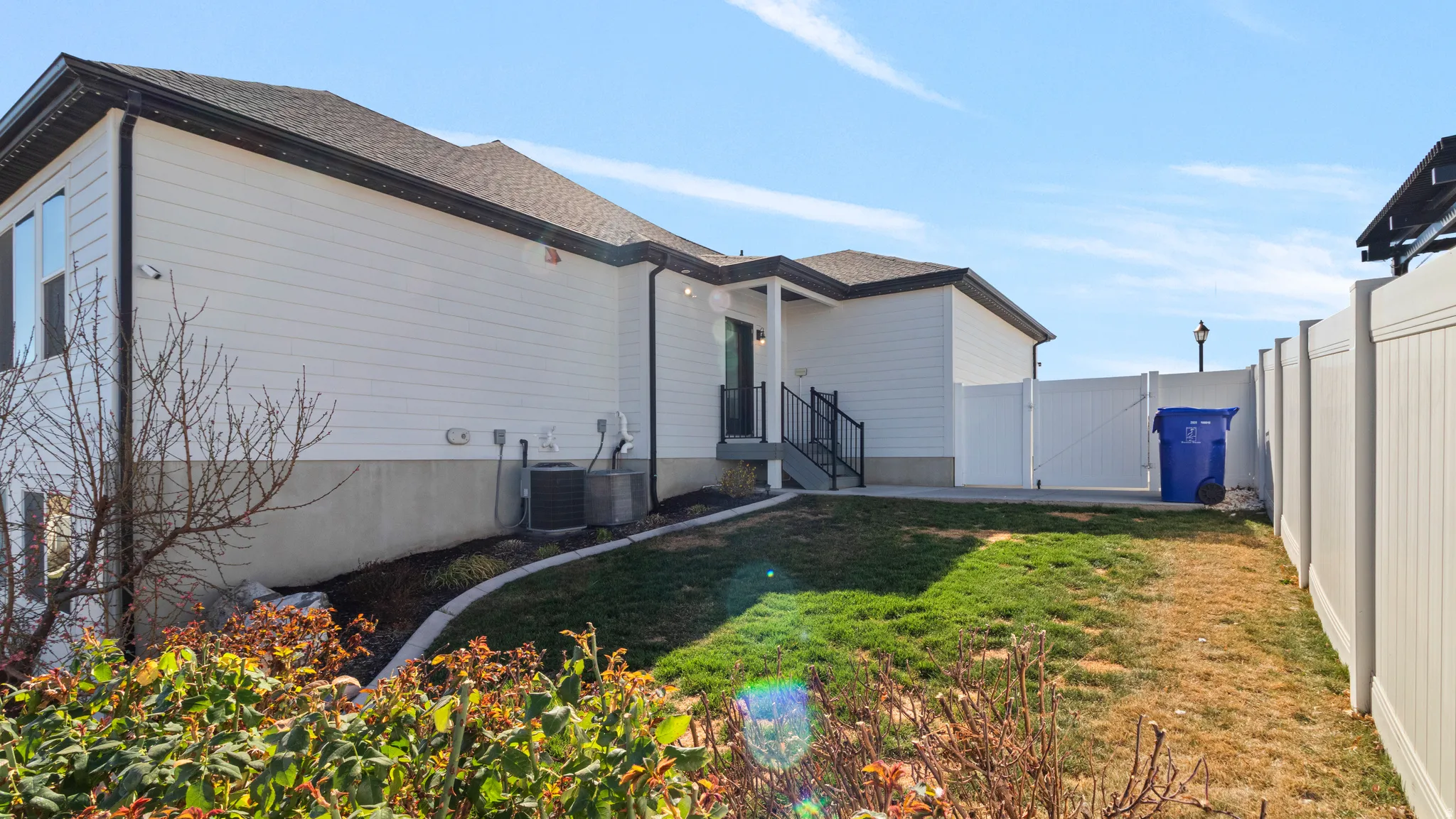 View of property exterior with a gate and roof with shingles