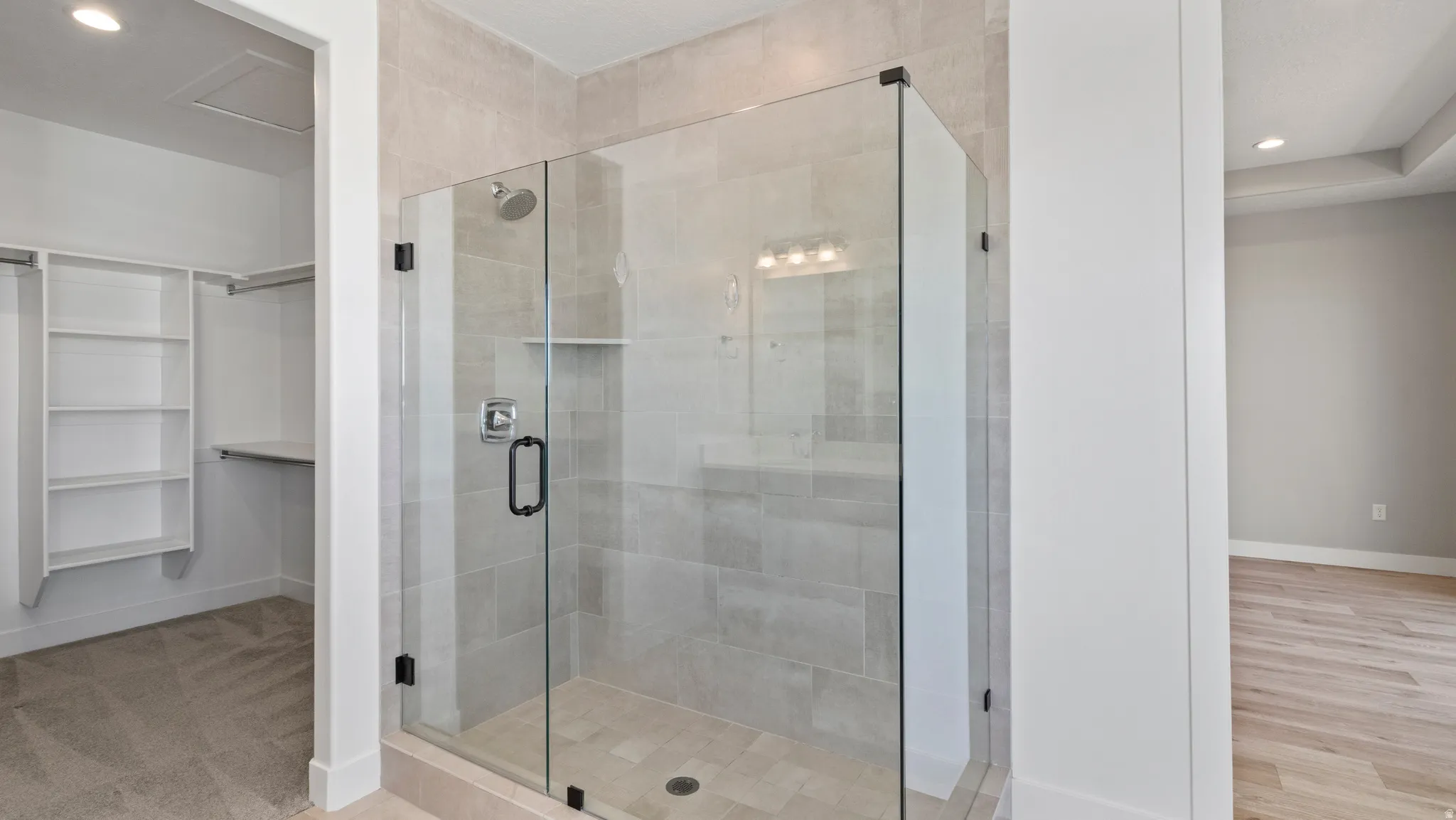 Full bathroom featuring recessed lighting, a shower stall, and a spacious closet