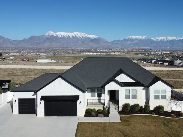Modern farmhouse style home with board and batten siding, a mountain view, an attached garage, and a porch