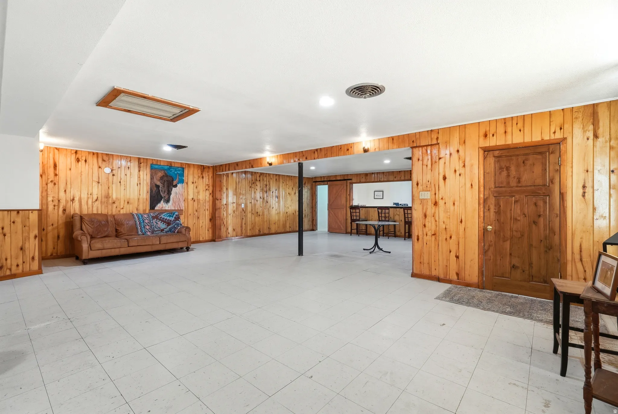 Finished below grade area with light flooring, wood walls, and recessed lighting