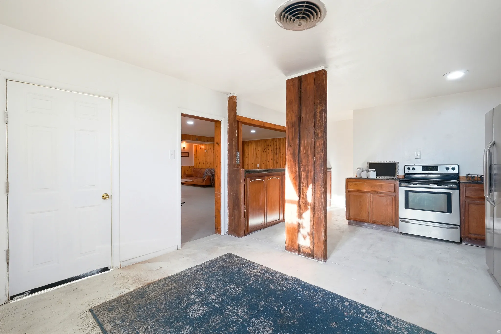 Kitchen featuring stainless steel appliances, wood finish cabinets, concrete floors, and recessed lighting
