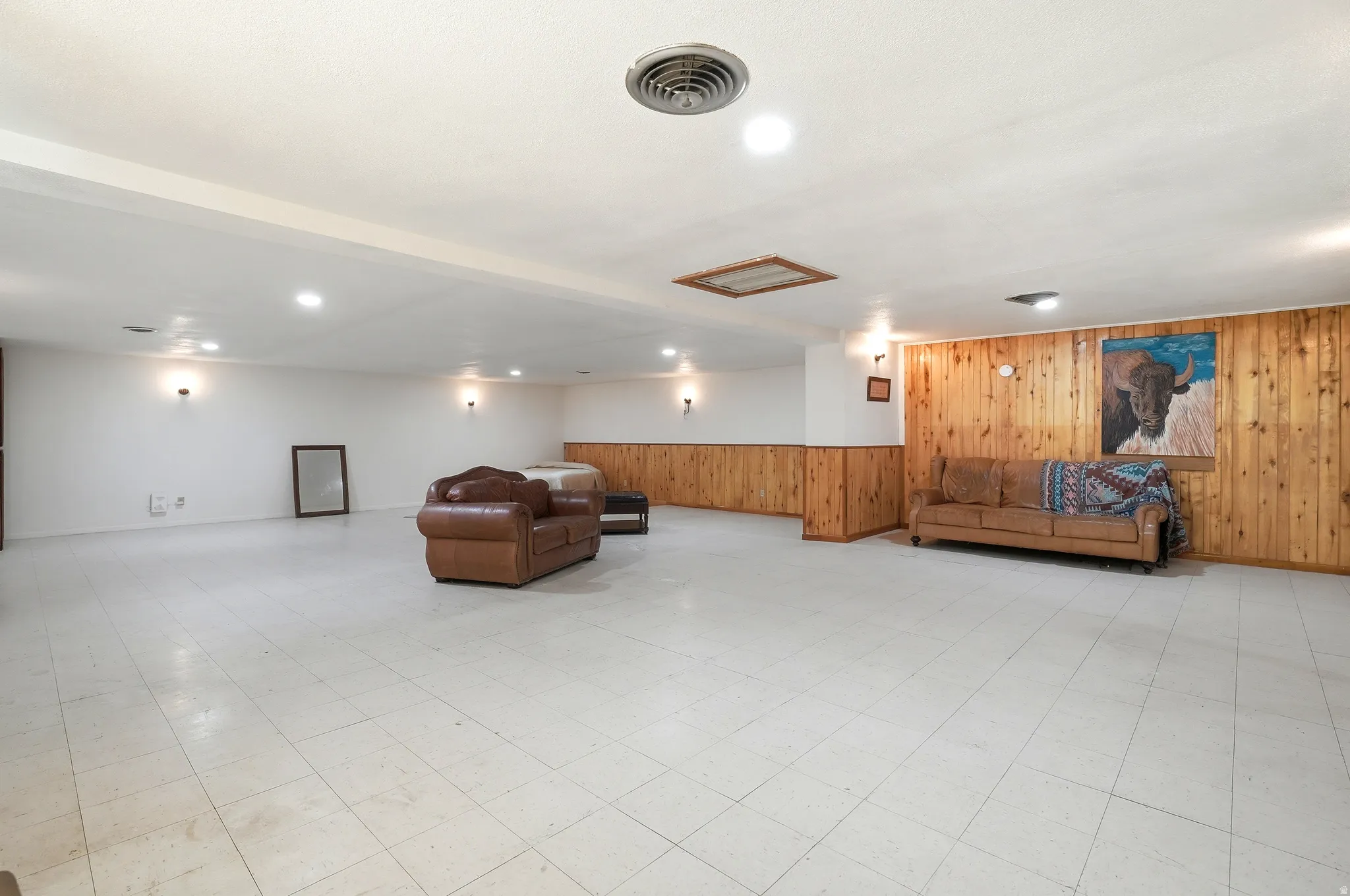 Living area with wood walls, light flooring, wainscoting, and recessed lighting