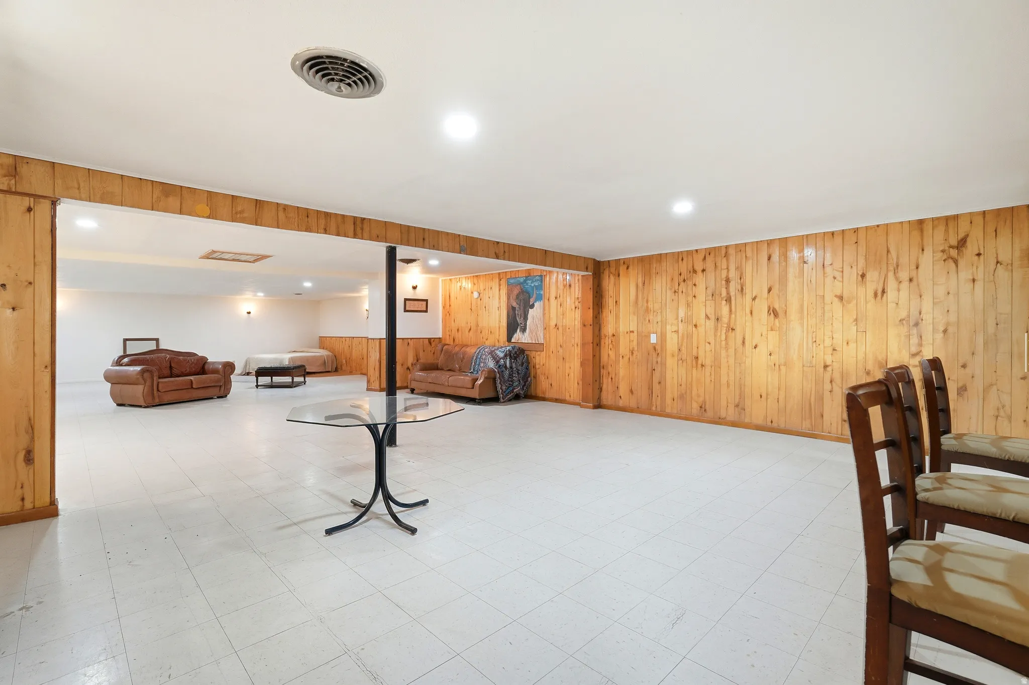 Finished basement featuring light flooring, wooden walls, and recessed lighting
