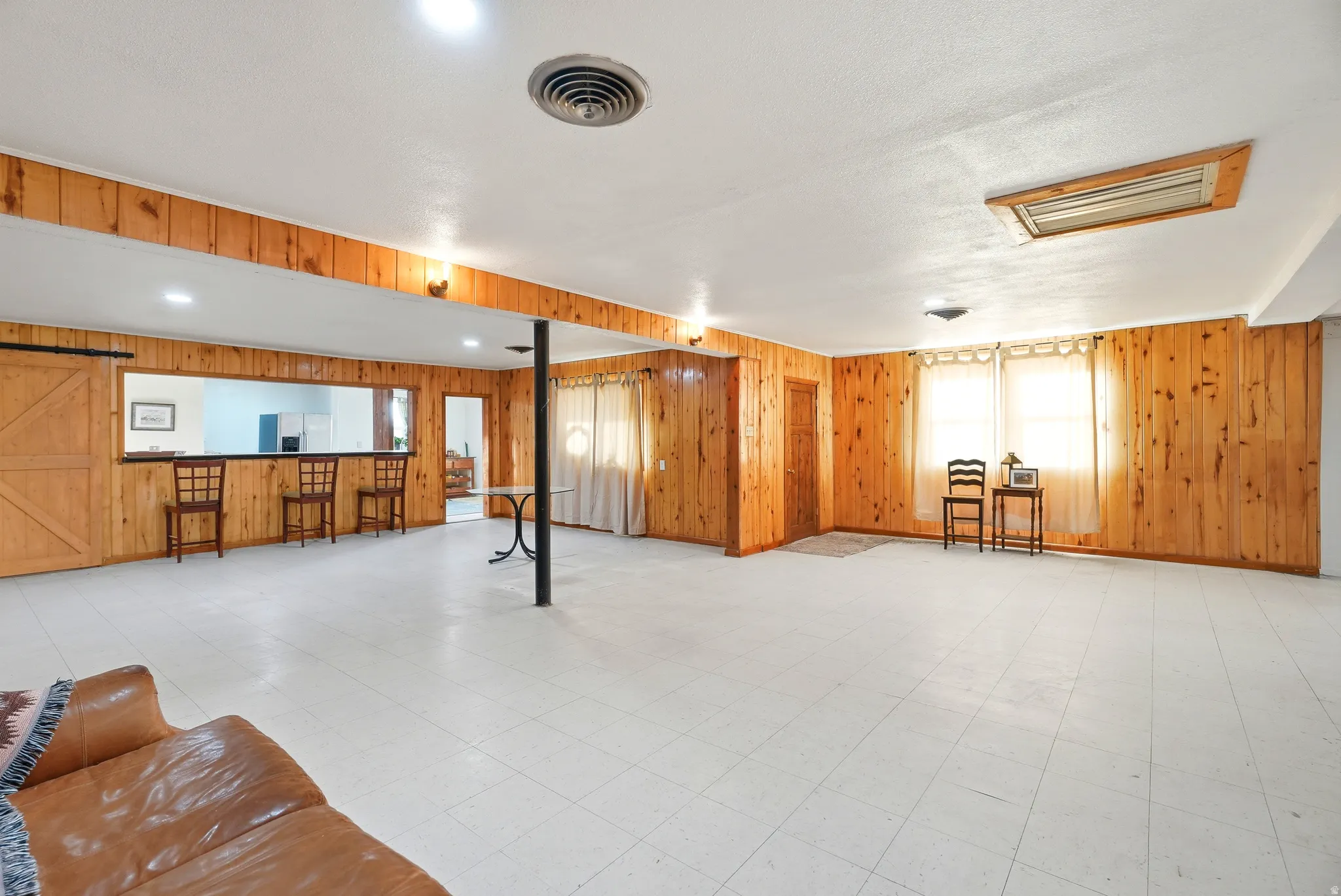 Below grade area featuring light floors and wood walls