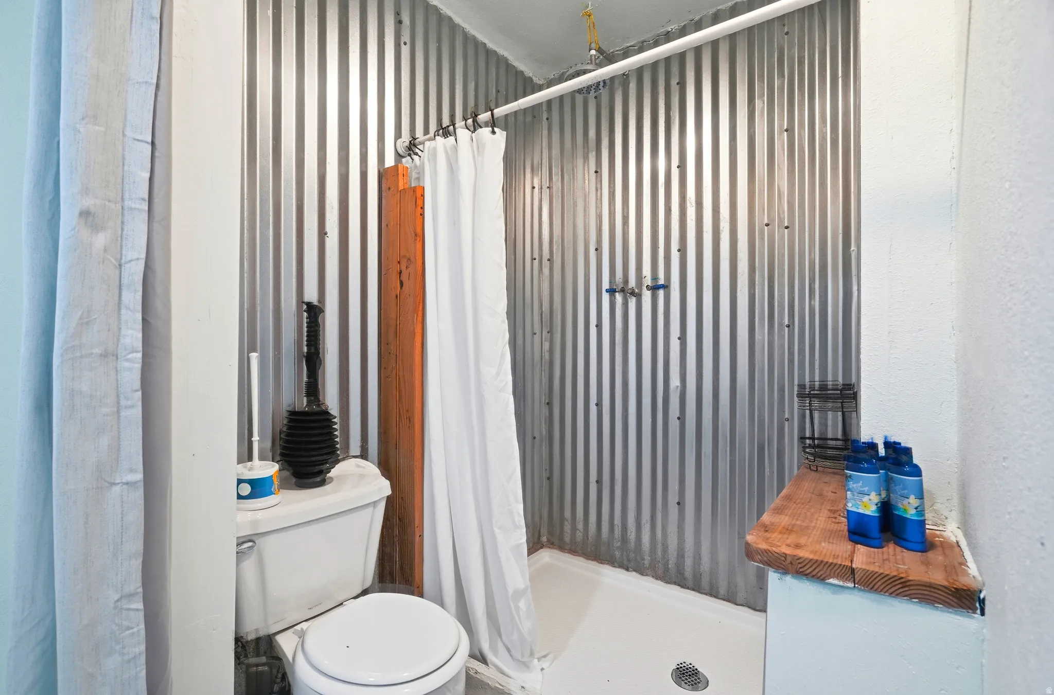 Bathroom featuring a stall shower and metal wall