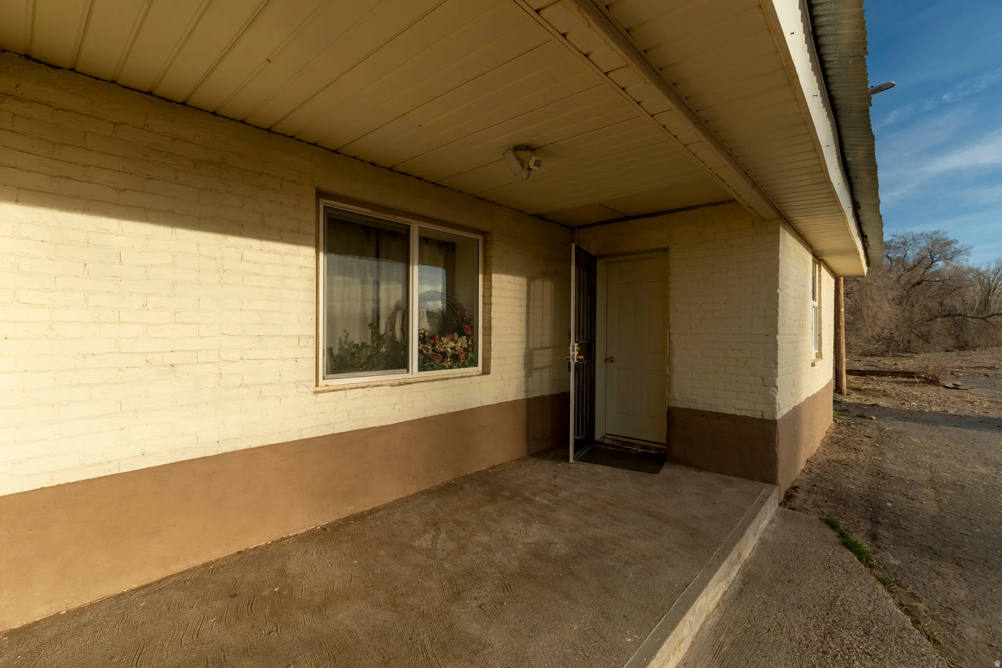 Doorway to property with a patio and brick siding