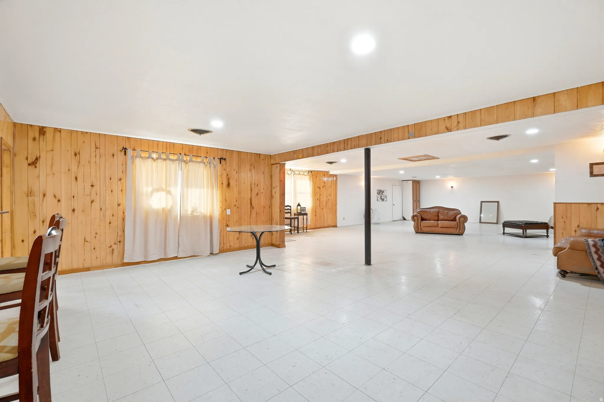 Basement with wood walls, light floors, and recessed lighting