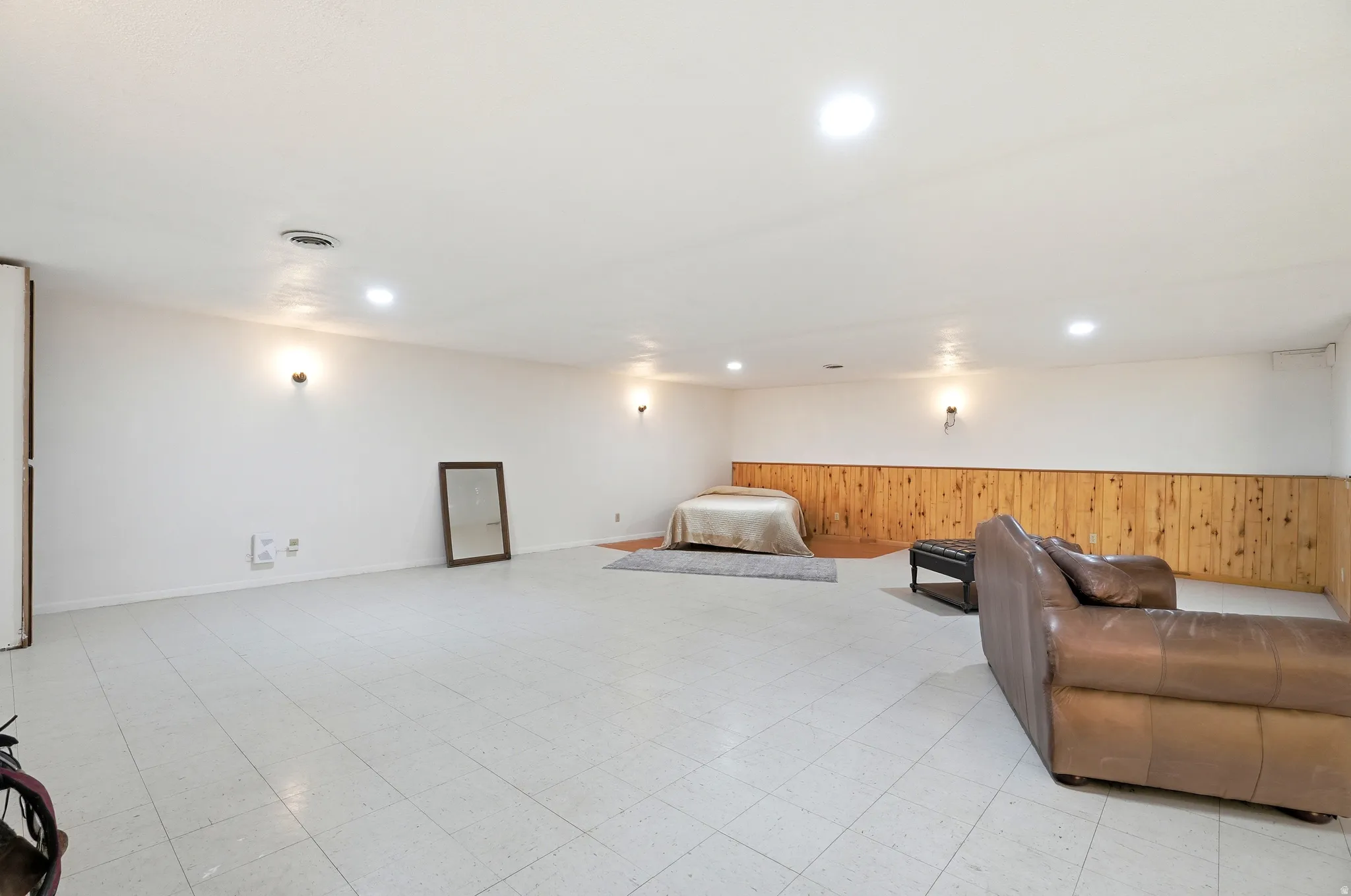 Sitting room featuring wood walls, a wainscoted wall, light flooring, and recessed lighting