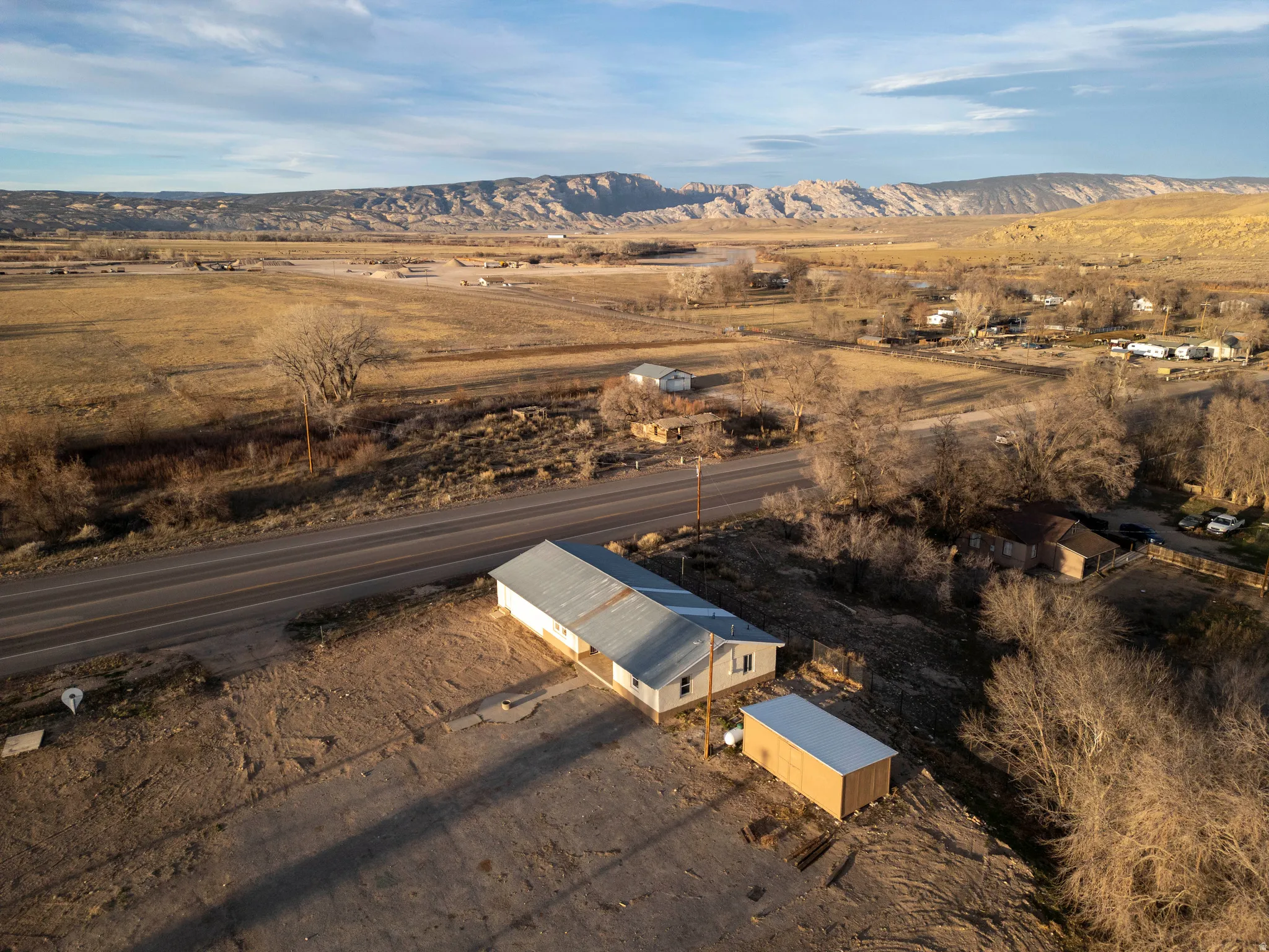 Aerial view of property and surrounding area featuring a mountain backdrop and rural landscape