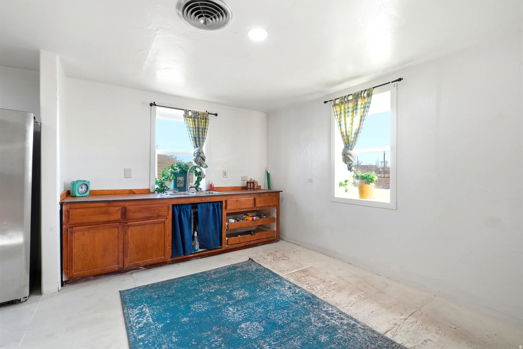 Bar with freestanding refrigerator and wood finish cabinets
