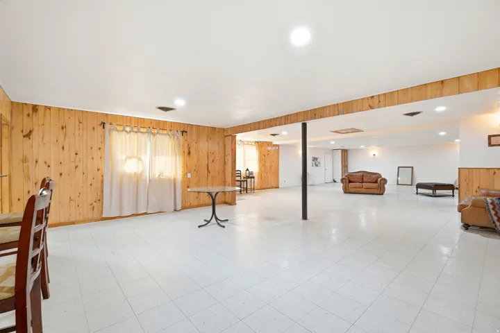 Basement with wood walls, light floors, and recessed lighting