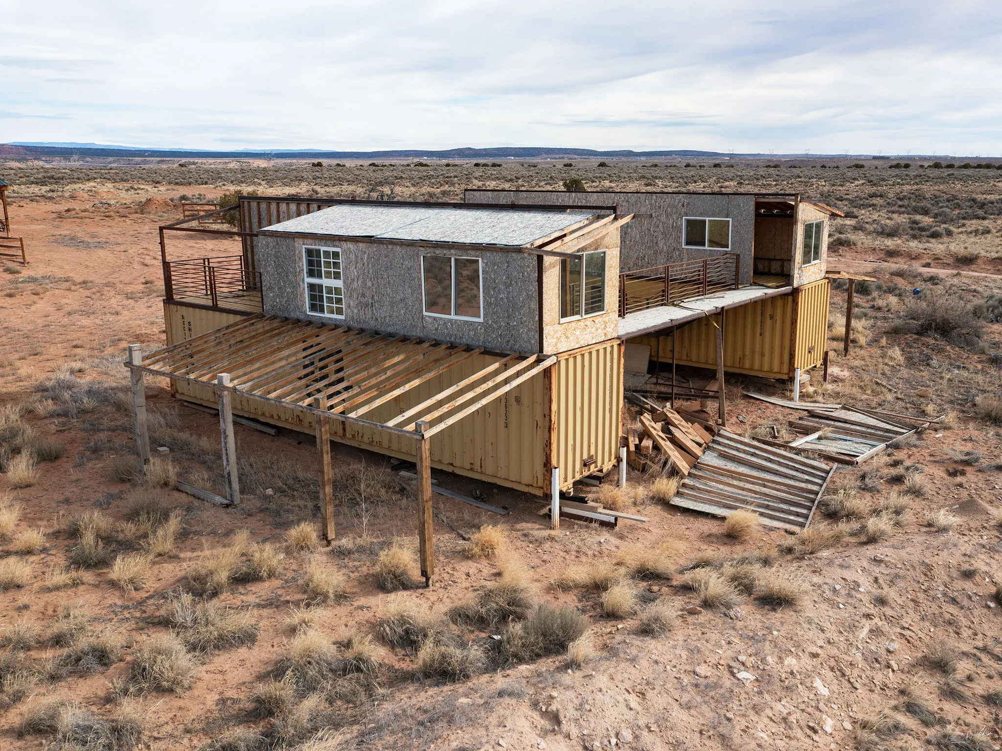 Back of property featuring a deck, view of desert landscape, and a view of rural / pastoral area