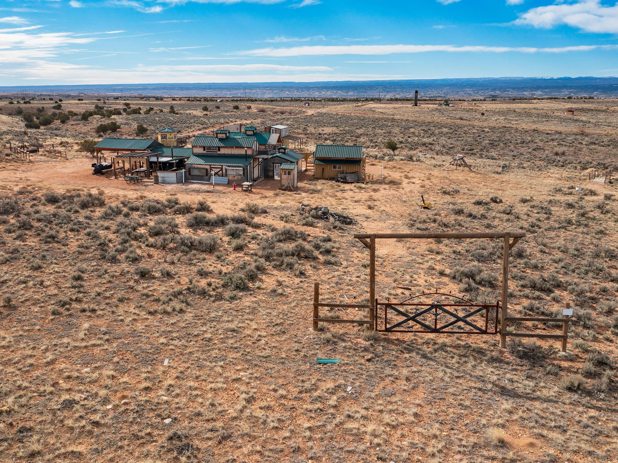 View of yard with a desert view, a gate, an outbuilding, and a view of rural / pastoral area