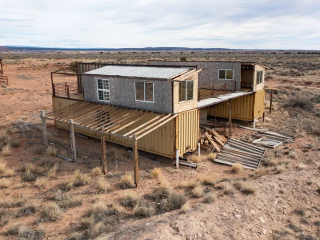Back of property featuring a deck, view of desert landscape, and a view of rural / pastoral area