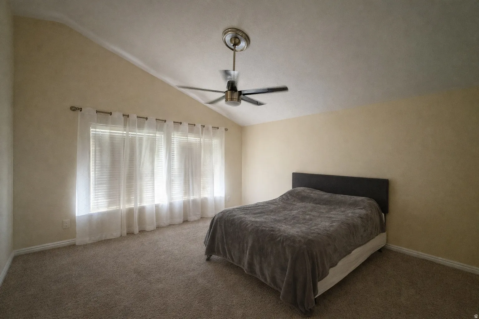 Bedroom featuring carpet floors, ceiling fan, and lofted ceiling