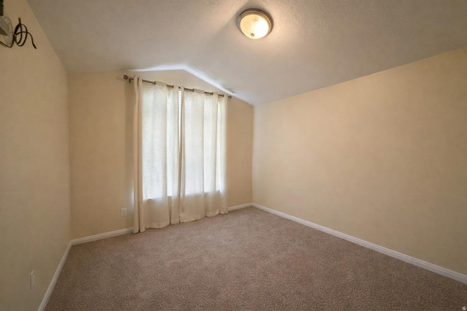 Empty room featuring carpet and baseboards