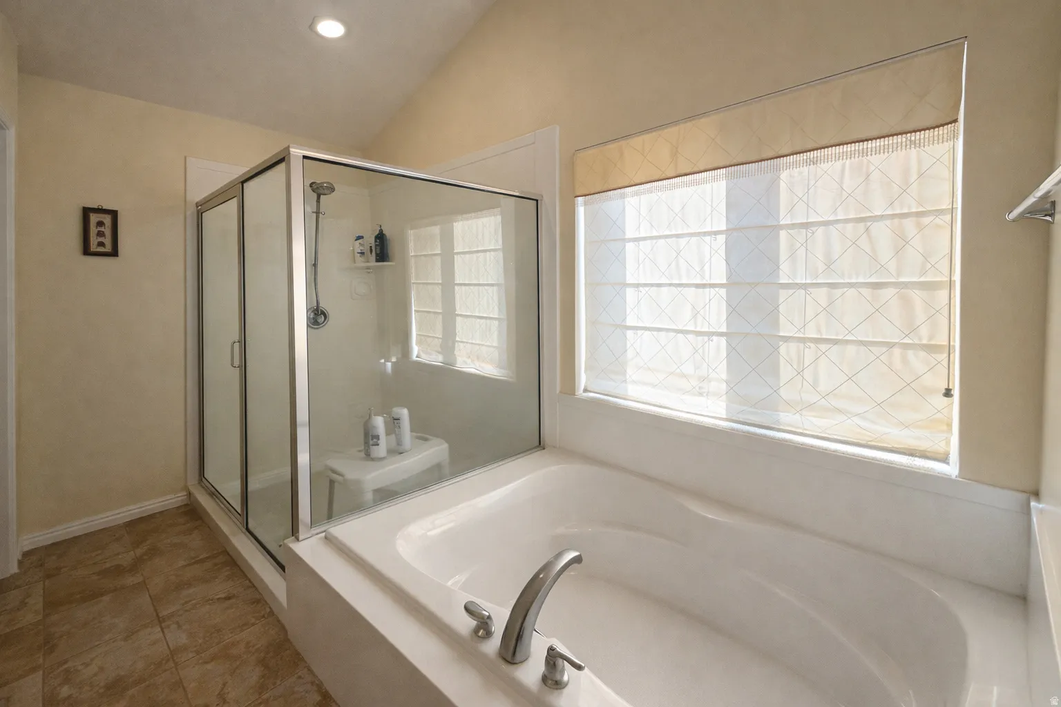 Bathroom featuring vaulted ceiling, a stall shower, a bath, and recessed lighting