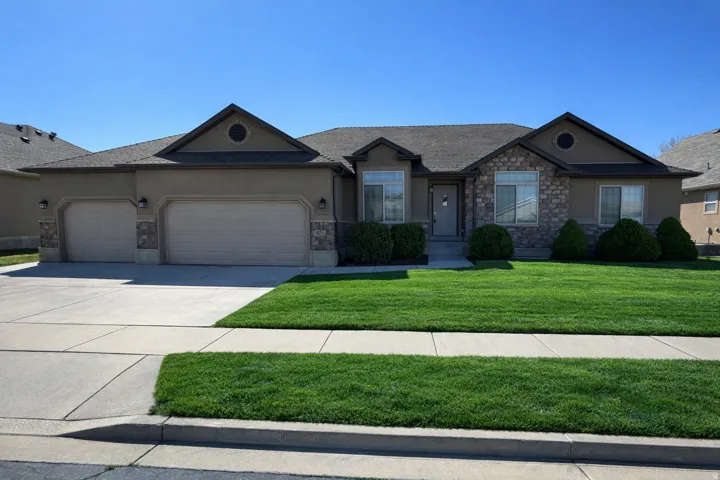 Single story home featuring stucco siding, an attached garage, concrete driveway, and a front lawn
