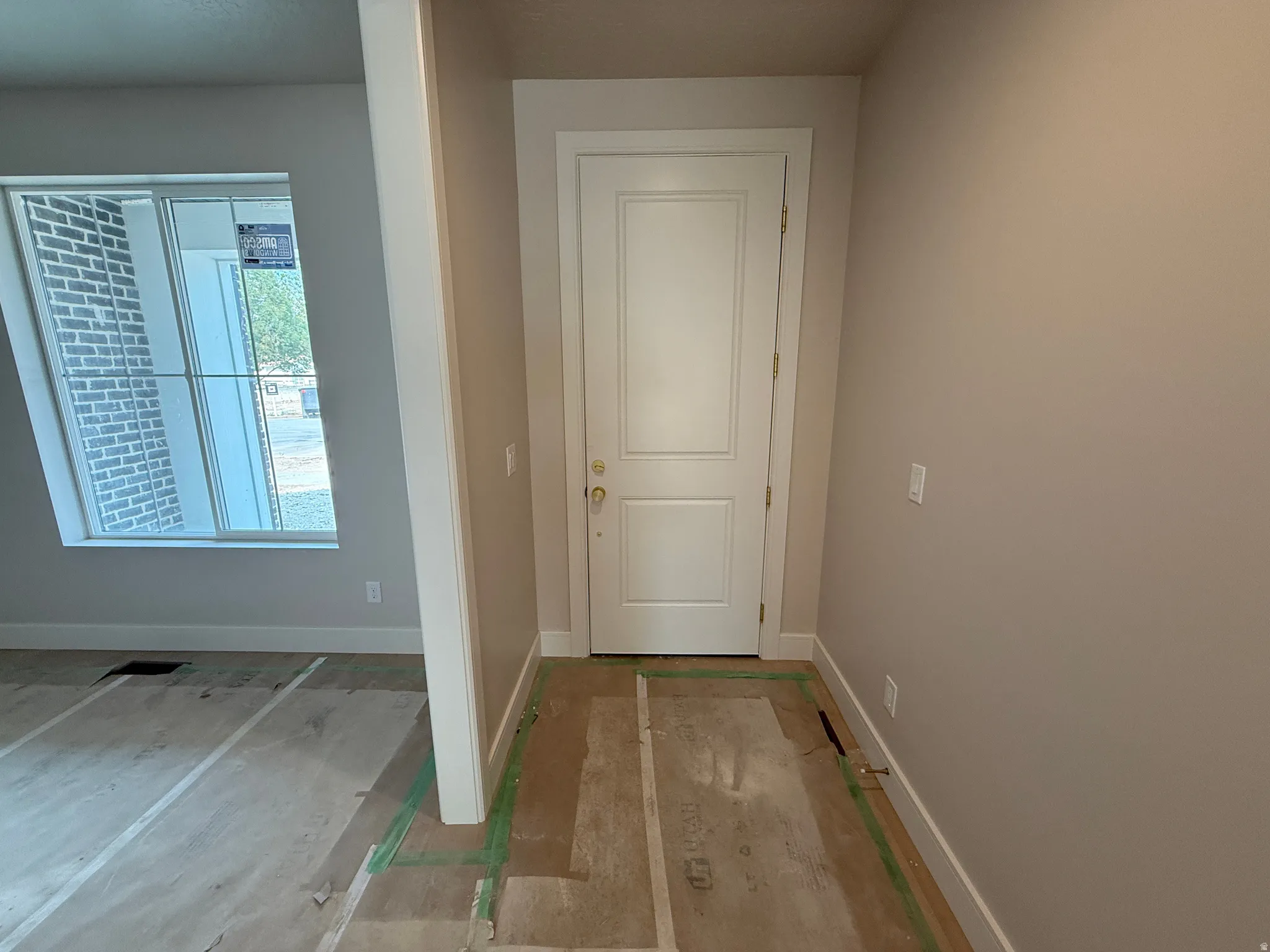 Entryway featuring a white paneled door, light neutral wall paint, and white trim