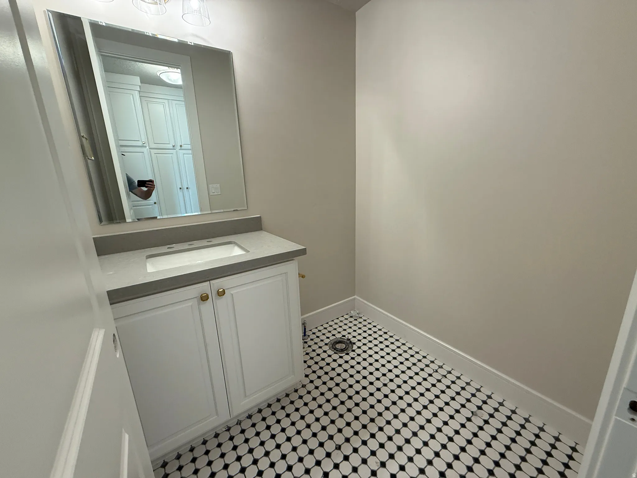 Bathroom featuring a white vanity with gold-toned hardware, a light gray countertop, and an undermount sink