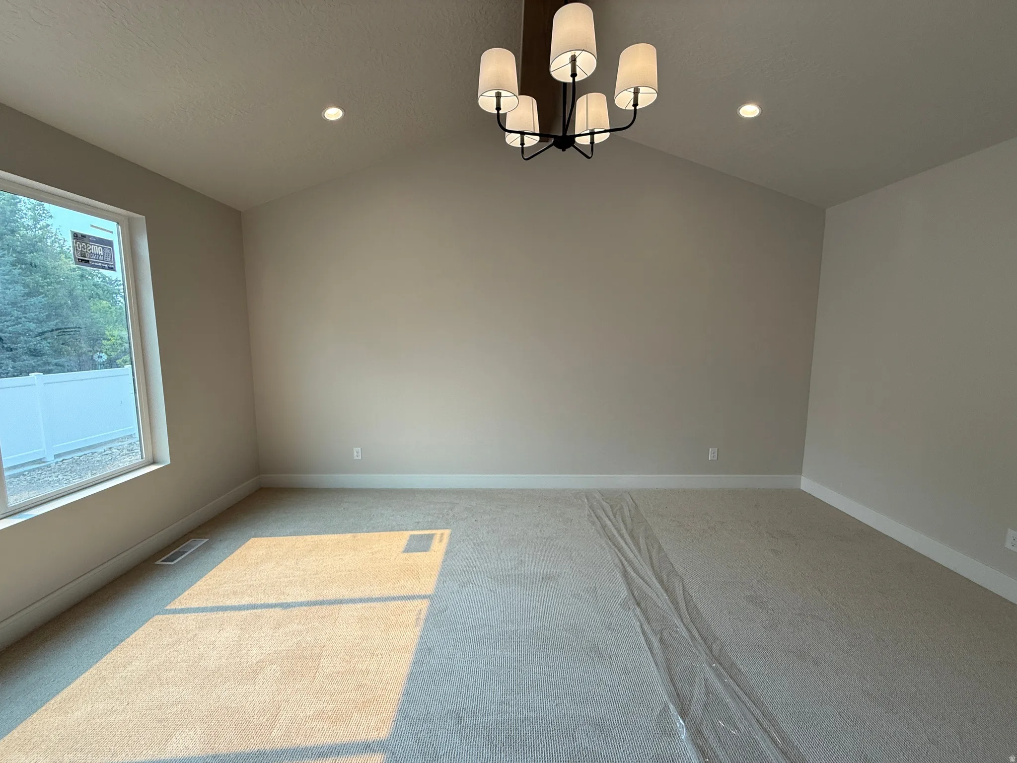 Primary Bedroom featuring vaulted ceilings, a contemporary chandelier, recessed lighting, and a large window