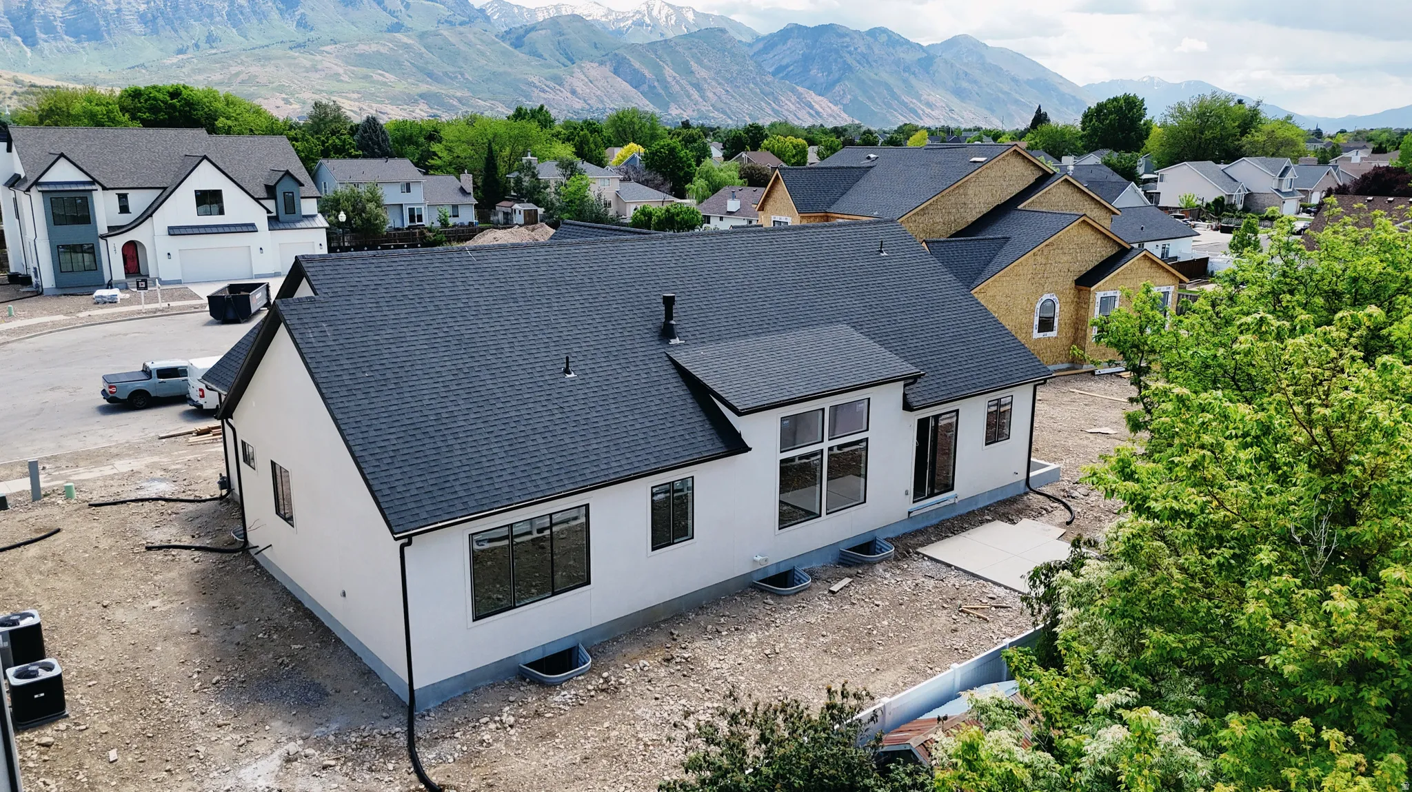 New construction residence featuring a dark asphalt shingle roof, white exterior siding, and black-framed windows
