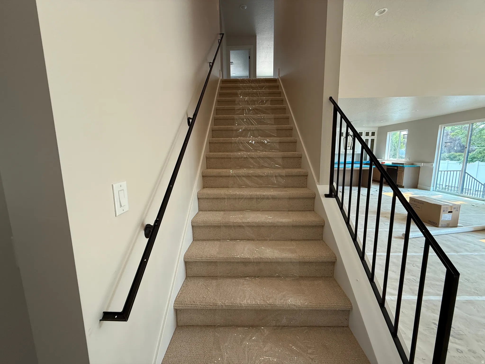 Carpeted staircase with contemporary black metal railings