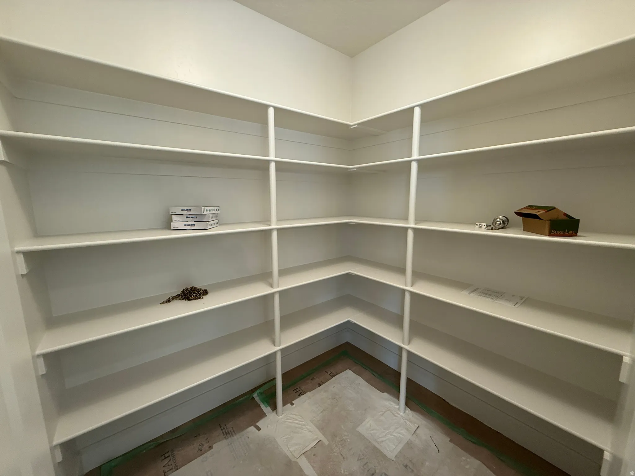 Expansive pantry featuring multi-level shelving, white finish, and a corner configuration