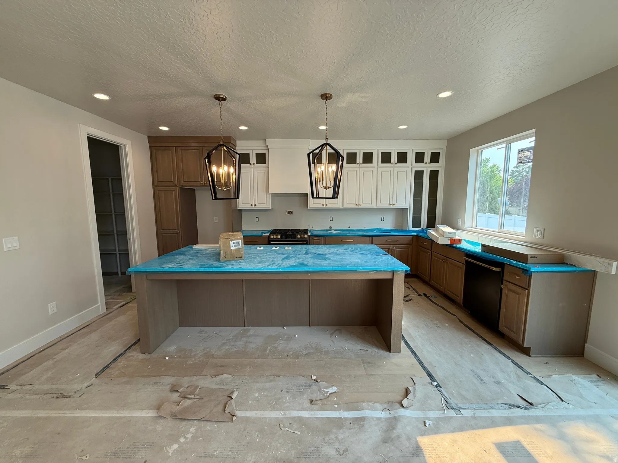Kitchen featuring a large island, contemporary pendant lighting, recessed ceiling lights, and a combination of white and wood-finish cabinetry