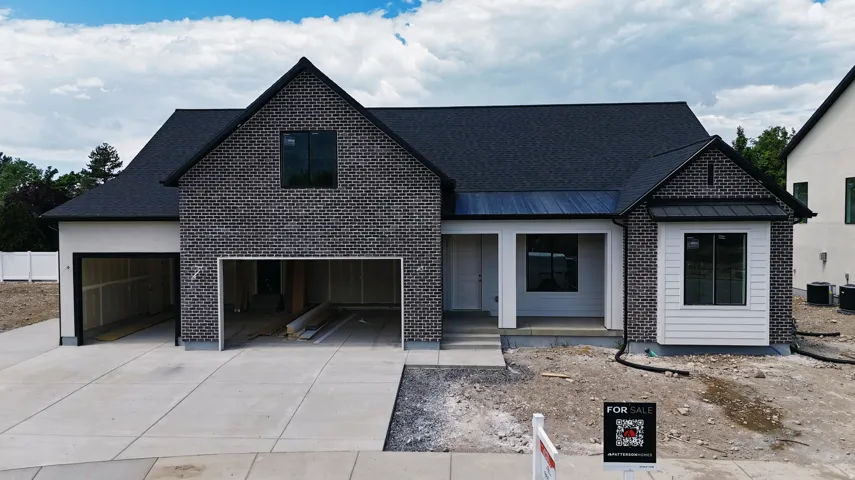 Modern black brick exterior with white siding accents and a covered front porch