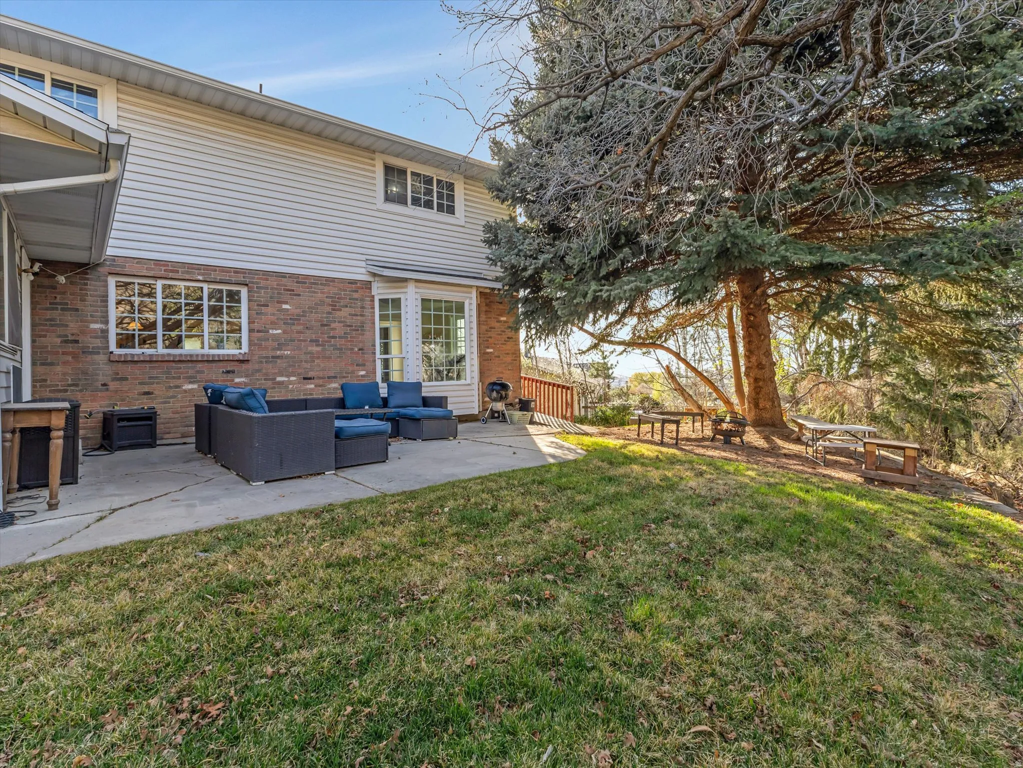 Rear view of house with an outdoor hangout area, brick siding, a patio, and a yard